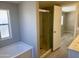 Bright bathroom features a bathtub with shower head and sliding glass shower doors at 420 S 98Th Way, Mesa, AZ 85208