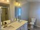 Bright bathroom features a double sink vanity with marbled countertop, modern fixtures, and toilet at 420 S 98Th Way, Mesa, AZ 85208