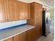 Well-lit kitchen featuring wooden cabinets, a gray countertop with blue tile backsplash, and stainless steel appliances at 420 S 98Th Way, Mesa, AZ 85208