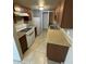 Kitchen featuring white appliances, tile floors, and brown cabinetry at 4258 N 68Th Ln, Phoenix, AZ 85033