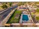 A sweeping aerial view showcases a backyard with pool, patio, pergola, and solar panels on a well-maintained home at 5607 E Enrose St, Mesa, AZ 85205