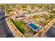 Aerial view showcasing home's layout with a pool, fire pit, pergola, solar panels and desert landscaping at 5607 E Enrose St, Mesa, AZ 85205