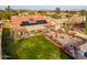 Backyard aerial features a well-manicured lawn, patio area, desert landscaping and solar panels at 5607 E Enrose St, Mesa, AZ 85205