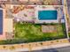 Aerial view of the backyard featuring a pool, lush lawn, a fire pit, and a custom-designed patio area at 5607 E Enrose St, Mesa, AZ 85205