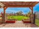 A picturesque backyard framed by a pergola and lush greenery, creating a serene outdoor space at 5607 E Enrose St, Mesa, AZ 85205
