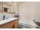 Bright bathroom featuring a soaking tub, a wooden vanity and neutral walls at 5607 E Enrose St, Mesa, AZ 85205