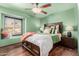 Cozy bedroom featuring a ceiling fan, wood floors, and a charming window seat at 5607 E Enrose St, Mesa, AZ 85205