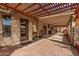 An inviting covered patio features a pergola, brick flooring, and ample space for outdoor enjoyment at 5607 E Enrose St, Mesa, AZ 85205