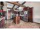 Bright kitchen featuring stainless steel appliances, dark wood cabinets, an island, and rustic beams at 5607 E Enrose St, Mesa, AZ 85205