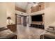 Expansive living room with tile flooring, wood-paneled accent wall, and large screen TV at 5607 E Enrose St, Mesa, AZ 85205