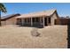 View of the backyard with a covered patio, rock feature, gravel landscaping, and a privacy fence and gate at 6460 S Springs Pl, Chandler, AZ 85249