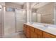 Bright bathroom featuring double sinks, vanity, shower stall with sliding glass door at 6460 S Springs Pl, Chandler, AZ 85249