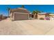 Well-maintained one-story house showcasing a desert landscape, a wide driveway, and a two-car garage at 6460 S Springs Pl, Chandler, AZ 85249