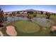 Scenic golf course aerial showcasing lush greenery, sand traps, a serene pond, and manicured landscaping for recreational enjoyment at 6460 S Springs Pl, Chandler, AZ 85249