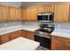 Well-equipped kitchen featuring wood cabinets, white quartz countertops, and stainless steel appliances at 6460 S Springs Pl, Chandler, AZ 85249