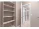Walk-in closet with built-in shelving leading to a bathroom at 6460 S Springs Pl, Chandler, AZ 85249