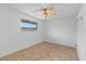 Bright bedroom features tile floors, a ceiling fan, and a window letting in natural light at 6707 N 42Nd Ave, Phoenix, AZ 85019