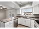 Bright kitchen with stainless appliances and white cabinets, opening to the backyard at 6713 S Jentilly Ln, Tempe, AZ 85283