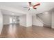 Spacious living room featuring hardwood floors, neutral paint, fan, and easy access to outdoor patio at 6713 S Jentilly Ln, Tempe, AZ 85283