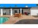 A covered patio offers an outdoor dining area with table, chairs, and barbecue, perfect for outdoor entertaining by the pool at 6729 E Sharon Dr, Scottsdale, AZ 85254