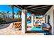 Covered patio with textured columns, outdoor seating, a vibrant blue rug, and views of the pool area for relaxed outdoor living at 6729 E Sharon Dr, Scottsdale, AZ 85254