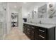 Modern bathroom featuring dual sinks, a walk-in closet, a full-sized mirror, and bright vanity lighting at 7700 E Gainey Ranch Rd # 127, Scottsdale, AZ 85258