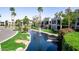 Community view of upscale condos beside a pond with rock features and mature landscaping at 7700 E Gainey Ranch Rd # 127, Scottsdale, AZ 85258