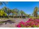 Community entrance featuring lush landscaping with flowers and mature shade trees at 7700 E Gainey Ranch Rd # 127, Scottsdale, AZ 85258