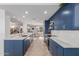 Beautiful open-concept kitchen with stainless steel appliances, blue cabinetry, marble counters, and views into the dining area at 7700 E Gainey Ranch Rd # 127, Scottsdale, AZ 85258