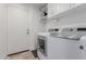 Well-lit laundry room with white cabinets and modern washer and dryer units at 7700 E Gainey Ranch Rd # 127, Scottsdale, AZ 85258