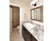 Well-lit bathroom features a granite countertop, dark wood cabinets, and a walk-in shower at 8717 E Spanish Barb Trl, Scottsdale, AZ 85258