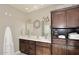 Bathroom featuring double sinks, dark wood cabinets, and a wreath for decor at 8717 E Spanish Barb Trl, Scottsdale, AZ 85258