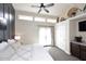 Bright and airy bedroom with a ceiling fan, access to the backyard, and adjacent wet bar at 8717 E Spanish Barb Trl, Scottsdale, AZ 85258