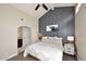 Stylishly appointed bedroom with accent wall, ceiling fan, and en suite bathroom at 8717 E Spanish Barb Trl, Scottsdale, AZ 85258