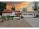 Stunning home with a three-car garage, desert landscaping, and a red-tile roof at sunset at 8717 E Spanish Barb Trl, Scottsdale, AZ 85258