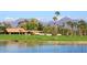 Scenic view of the golf course, with a serene lake, palm trees, and mountain backdrop at 8717 E Spanish Barb Trl, Scottsdale, AZ 85258