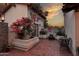 Charming outdoor patio with brick pavers, lush plants, and a seating area at sunset at 8717 E Spanish Barb Trl, Scottsdale, AZ 85258