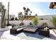 Inviting outdoor patio with a large sectional, lounge chair, and shaded umbrella offers relaxation and comfort at 8717 E Spanish Barb Trl, Scottsdale, AZ 85258