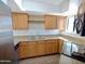 Galley kitchen with oak cabinets, stainless steel appliances and sink and wine glass rack at 985 N Granite Reef Rd # 134, Scottsdale, AZ 85257