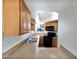 Galley kitchen featuring light wood cabinets, black appliances, and a stainless steel sink at 985 N Granite Reef Rd # 134, Scottsdale, AZ 85257