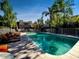 A community pool with lounge chairs is surrounded by mature landscaping and fencing at 985 N Granite Reef Rd # 134, Scottsdale, AZ 85257