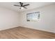 This bedroom boasts a ceiling fan, a window with blinds, and attractive and durable wood-look flooring at 10750 W Abbott Ave, Sun City, AZ 85351