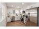 Modern kitchen featuring white cabinets, stainless steel appliances, and wood-look floors at 10750 W Abbott Ave, Sun City, AZ 85351