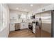 Modern kitchen featuring white cabinets, stainless steel appliances, and wood-look floors at 10750 W Abbott Ave, Sun City, AZ 85351