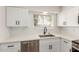Bright kitchen featuring white subway tile backsplash, stainless steel sink, and ample counter space at 10750 W Abbott Ave, Sun City, AZ 85351