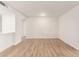 Bright living room features wood-look floors and white walls at 10750 W Abbott Ave, Sun City, AZ 85351