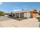 View of home showcasing spacious driveway, covered carport, desert landscaping, and great curb appeal at 11001 N Madison Dr, Sun City, AZ 85351