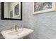 Stylish powder room featuring designer wallpaper, a pedestal sink, and modern fixtures at 1123 E Mcneil St, Phoenix, AZ 85042