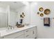 Bright bathroom with double sinks, white cabinets, a large mirror, and stylish gold wall decor at 1123 E Mcneil St, Phoenix, AZ 85042