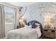 Relaxing bedroom featuring a decorative mural, neutral tones, and soft, inviting bedding at 1123 E Mcneil St, Phoenix, AZ 85042